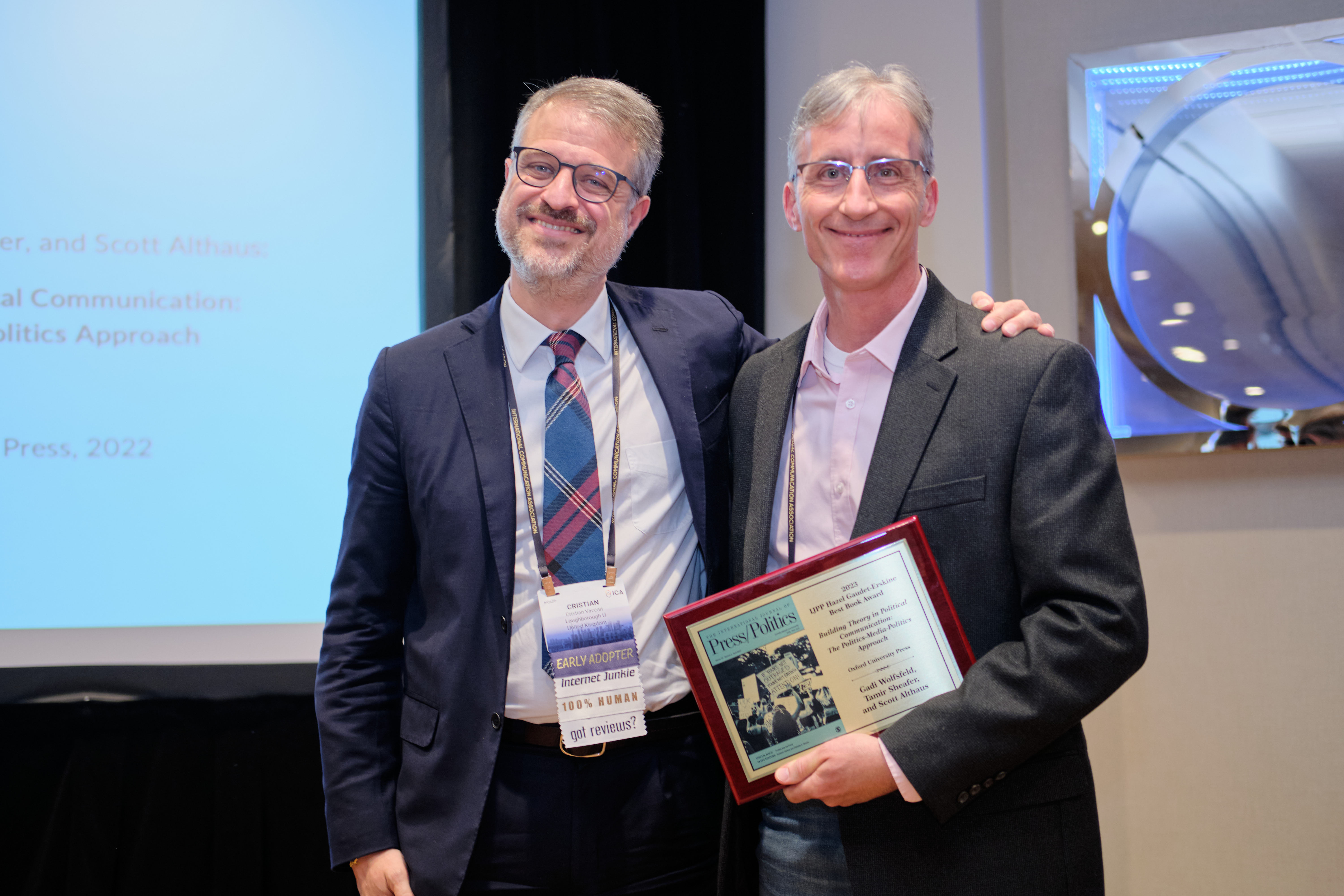 Scott Althaus accepting the 2023 IJPP Best Book Award from Cristian Vaccari at ICA